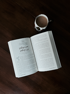 A book on a table with a cup of coffee
